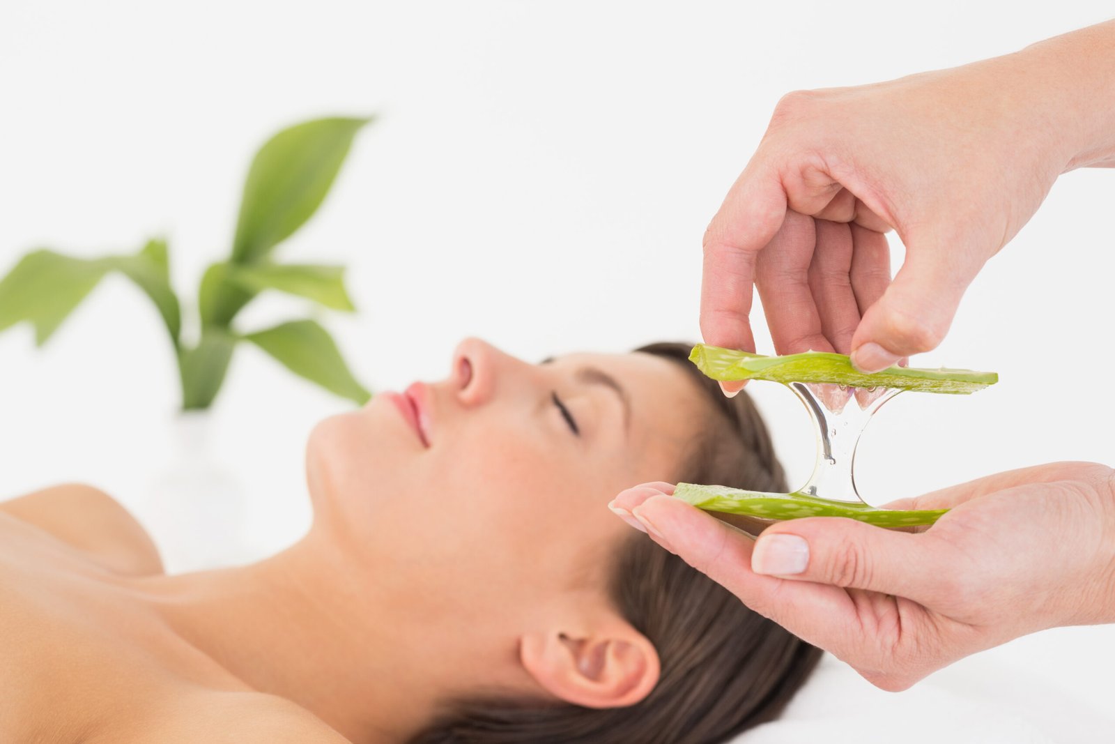 Side view of an attractive young woman receiving aloe vera massage at spa center